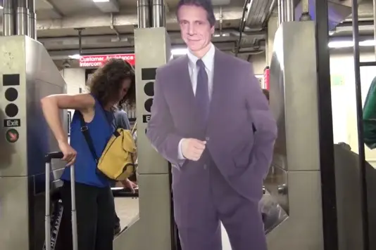 Cuomo poses with turnstile